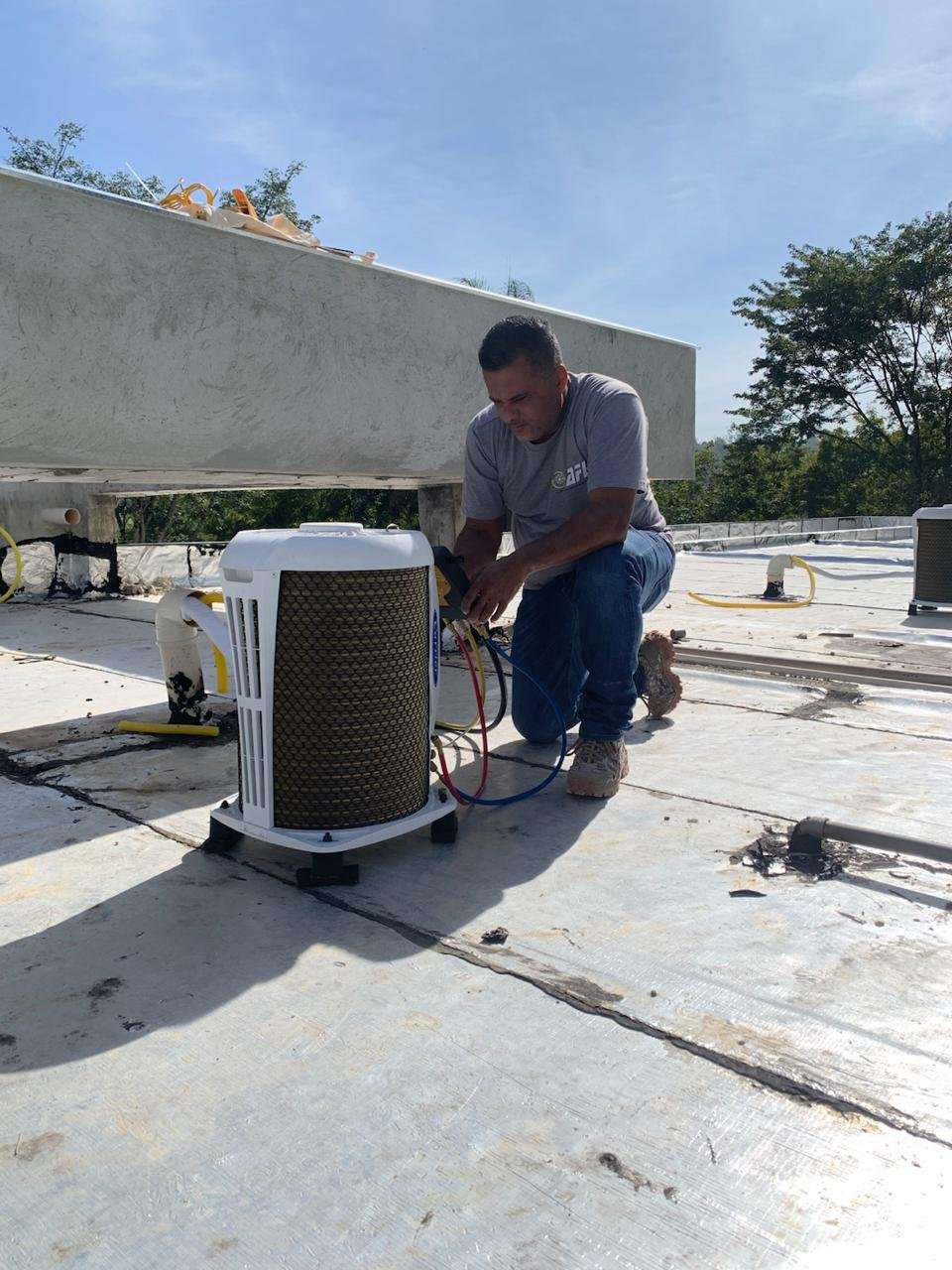 Técnico da AFL realizando carga de gás em condensadora Carrier